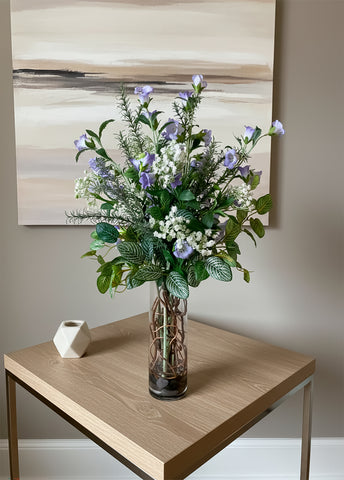 Arreglo Floral con Campanula, Rosemary y Follajes Artificiales en Florero de Vidrio