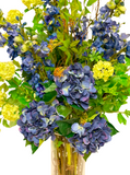 Arreglo Floral con Hidrangeas y Delphiniums Artificiales en Tonos Azules en Cilindro de Vidrio con Agua Acrílica