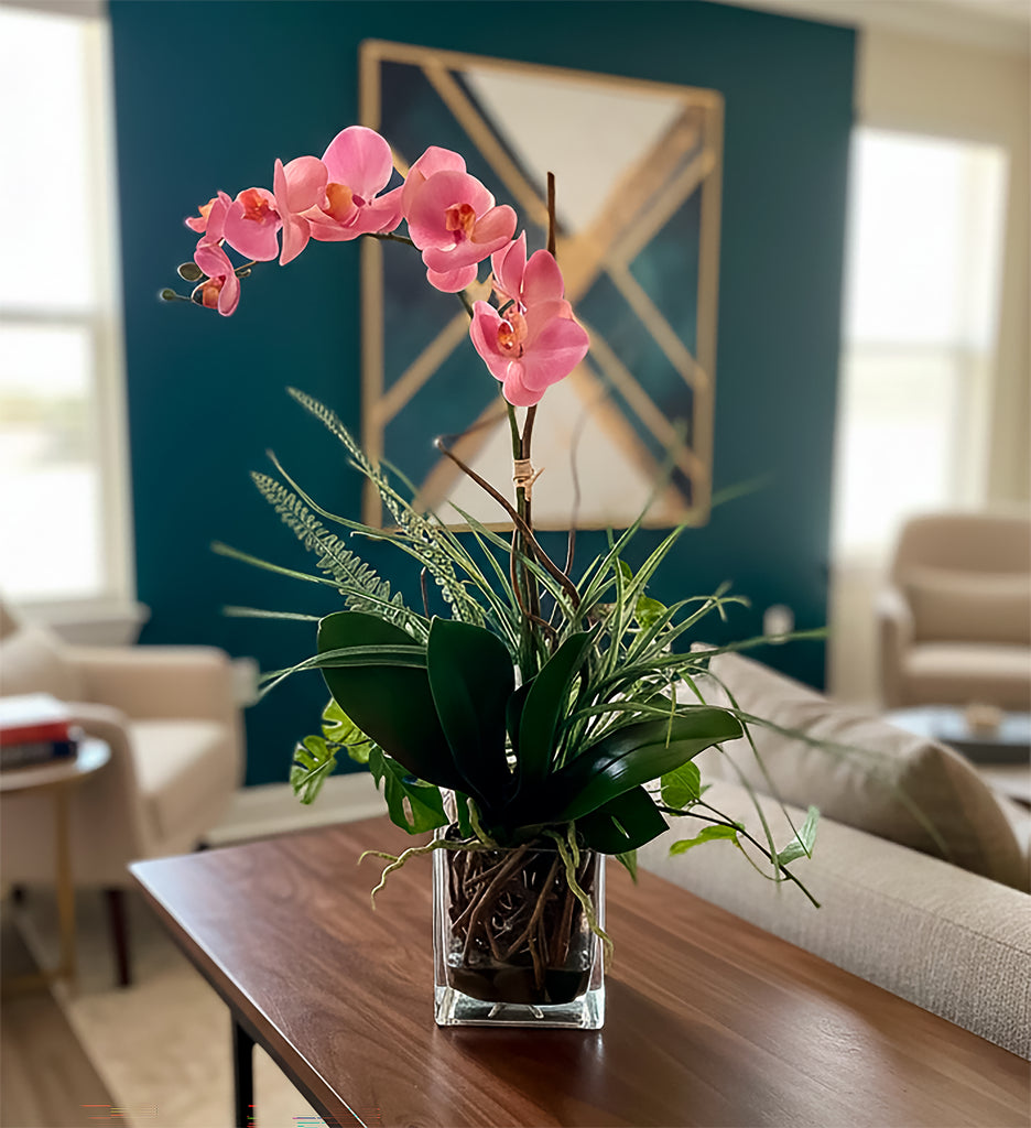 Orquideario con Phalaenopsis Rosa y Follajes Artificiales en Base Cuadrada de Vidrio