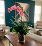 Orquideario con Phalaenopsis Rosa y Follajes Artificiales en Base Cuadrada de Vidrio