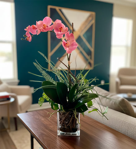 Orquideario con Phalaenopsis Rosa y Follajes Artificiales en Base Cuadrada de Vidrio