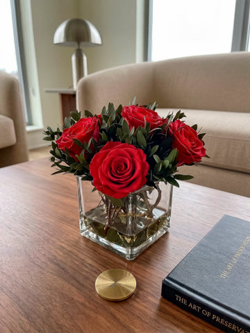 Arreglo Floral con 5 Rosas Preservadas Color Rojo en Base Cuadrada de Vidrio con Agua Acrílica
