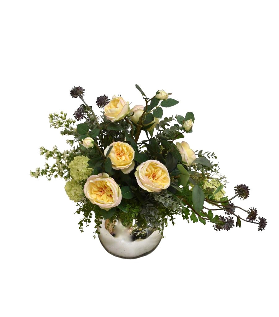 Centro de Mesa con Rosas en Tonos Amarillos y Follajes Artificiales en Base de Vidrio Tipo Espejo.