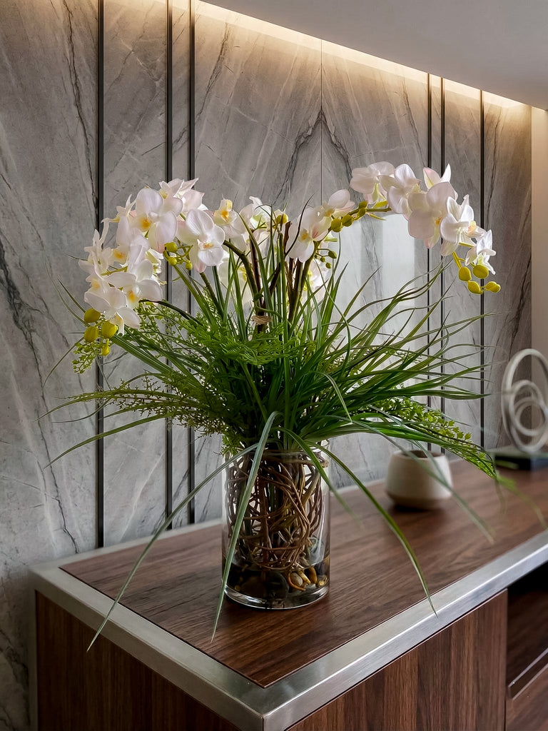 Orquideario con Mini Phalaenopsis y Follajes Artificiales en Florero de Vidrio con Agua Acrílica