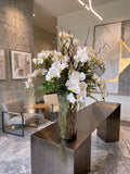Orquideario con Phalaenopsis Blancas y Follajes Artificiales en Florero de Vidrio con Agua Acrílica