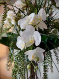 Orquideario con Phalaenopsis Blancas y Follajes Artificiales en Florero de Vidrio con Agua Acrílica