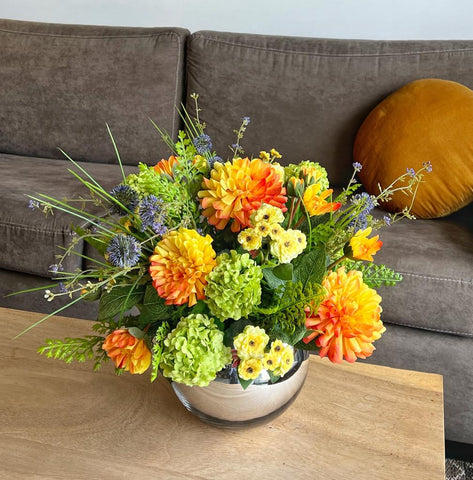 Centro de Mesa Artificial con Dahlias en Tonos Naranjas Base Cristal Espejo.
